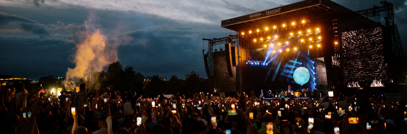 View of the Main Stage during a performance, audience members have phones in the air 